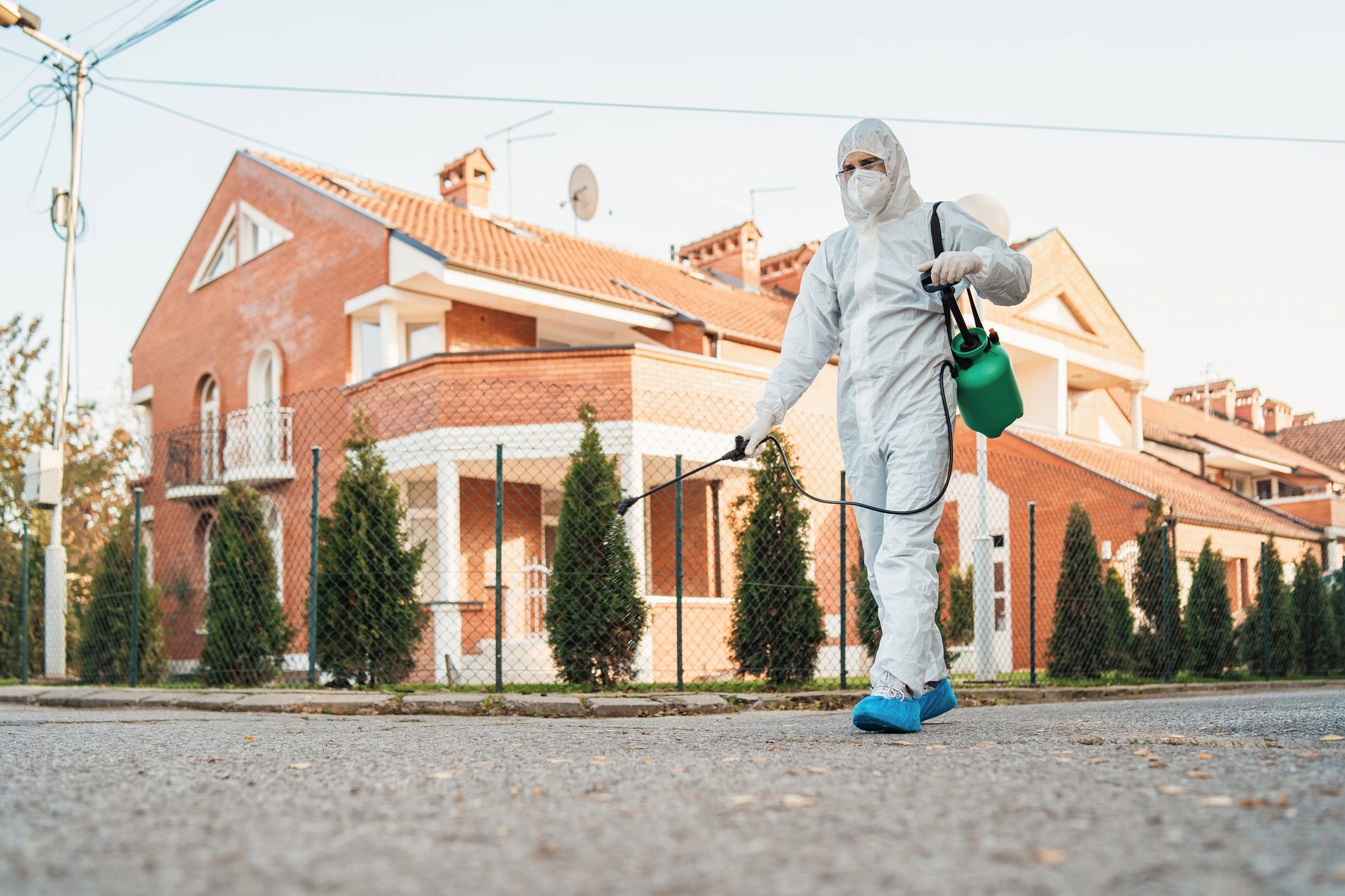 Pest control technician applying treatment outdoors